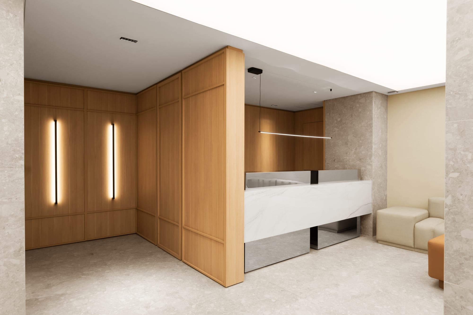 Recepción con paneles de madera y luminaria lineal